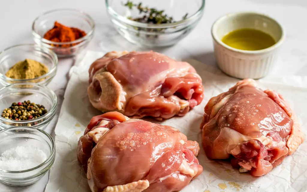 Raw chicken thighs and seasonings for air fryer recipe